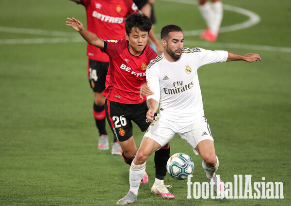 MADRID, SPAIN - JUNE 24: Daniel Carvajal of Real Madrid is taackled by Takefusa Kubo of RCD Mallorca during the Liga match between Real Madrid CF and RCD Mallorca at Estadio Alfredo Di Stefano on June 24, 2020 in Madrid, Spain. (Photo by Gonzalo Arroyo Moreno/Getty Images)