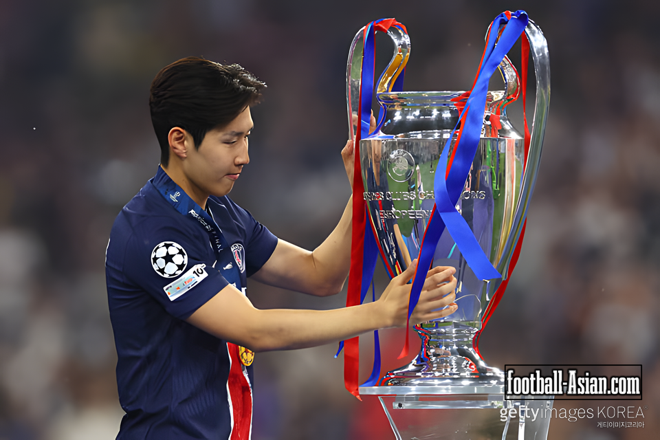 MUNICH, GERMANY - MAY 31: Lee Kang-in of Paris Saint-Germain reacts as he walks past the UEFA Champions League trophy after collecting his winners medal after defeating FC Internazionale, to secure Paris Saint-Germain's first ever UEFA Champions League title in the club's history and a record UEFA Champions League Final winning scoreline of 5-0, following the UEFA Champions League Final 2025 between Paris Saint-Germain and FC Internazionale Milano at Munich Football Arena on May 31, 2025 in Munich, Germany. (Photo by Justin Setterfield/Getty Images)