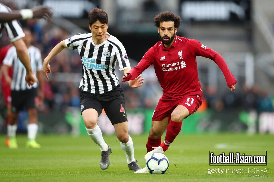 NEWCASTLE UPON TYNE, ENGLAND - MAY 04: Mohamed Salah of Liverpool runs with the ball under pressure from Ki Sung-Yeung of Newcastle United during the Premier League match between Newcastle United and Liverpool FC at St. James Park on May 04, 2019 in Newcastle upon Tyne, United Kingdom. (Photo by Clive Brunskill/Getty Images)